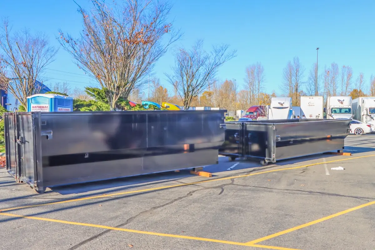 Professional dumpster rental service with roll-off container on residential driveway in North Providence